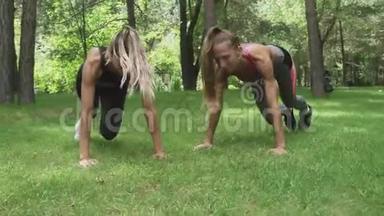 两位年轻的美女<strong>正在</strong>公园<strong>里</strong>做木板运动，健身模特们<strong>正在</strong>锻炼身体